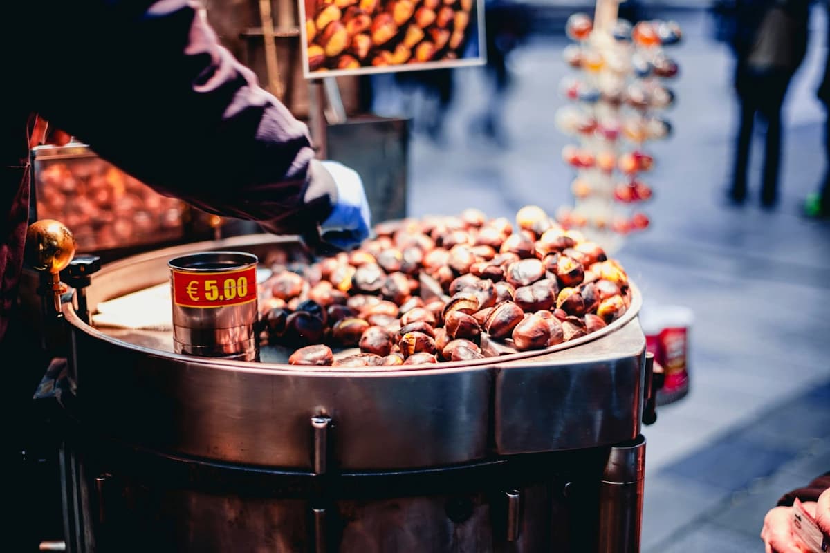 Men that making hot and aromatic chestnuts on fire in autumn.